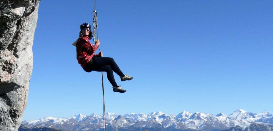 A woman hanging in mid-air while she rappels